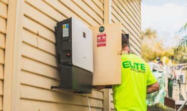 Een technicus controleert een zonnepaneel omvormer op storingen en foutcodes.